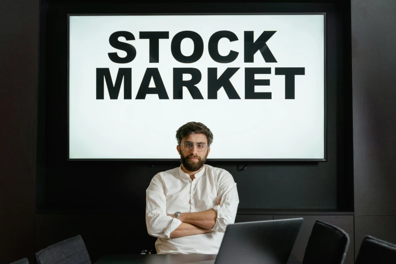 a man sitting at a table with a laptop in front of him, a photo, pexels, renaissance, trading stocks, avatar image, a person standing in front of a, 2 0 7 7