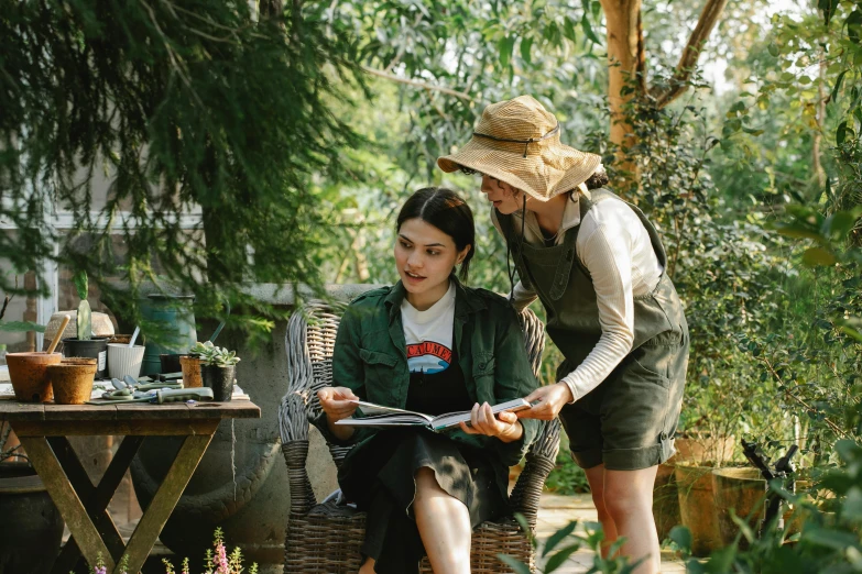 a couple of women standing next to each other in a garden, pexels contest winner, plein air, reading a book, lucy hale and maisie williams, inspect in inventory image, permaculture