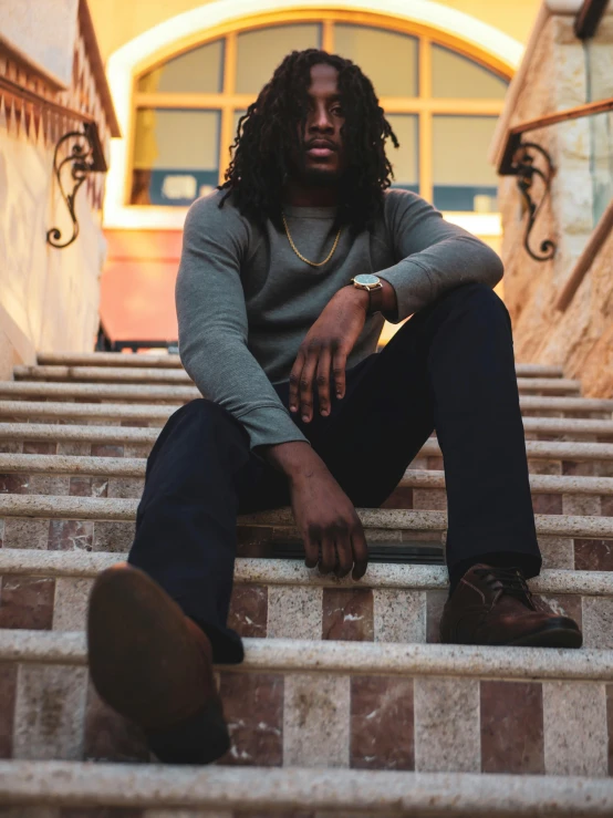 a man sitting on the steps of a building, inspired by Terrell James, pexels contest winner, chief keef, green corduroy pants, wearing a dark sweater, fine details portrait