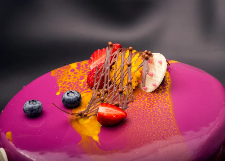 a purple cake topped with strawberries and blueberries, inspired by Charles Le Roux, pexels contest winner, process art, orange purple and gold ”, gourmet restaurant, chocolate art, glossy surface