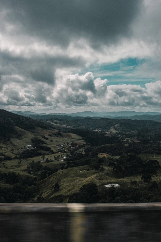 a car driving down the road on a cloudy day, a matte painting, by Niklaus Manuel, unsplash contest winner, looking down at the valley, puerto rico, panorama view, unsplash 4k