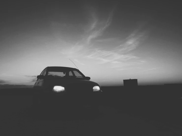 a black and white photo of a car in the dark, a black and white photo, pexels contest winner, romanticism, dusk setting, 80s photo, square, faded and dusty