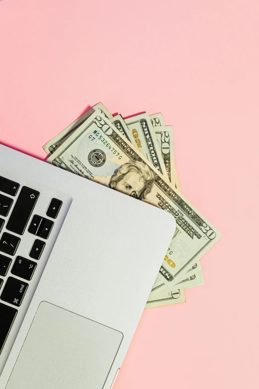 a laptop computer sitting on top of a pile of money, by Josh Bayer, trending on unsplash, pink gradient background, instagram photo, thumbnail, flatlay