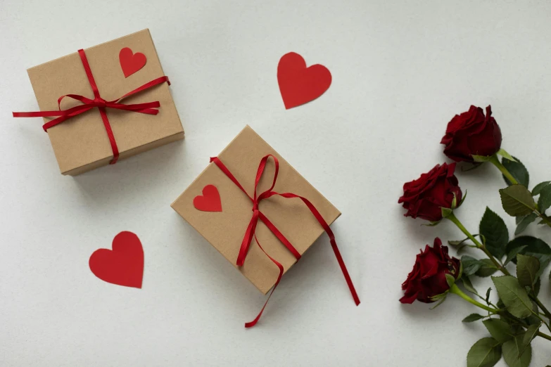 a couple of boxes sitting on top of a table, pexels contest winner, romanticism, small red roses, hearts, packaging design, brown paper