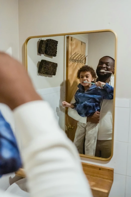 a man brushing his teeth in front of a mirror, a picture, by Paul Davis, pexels contest winner, father holds child in the hand, man is with black skin, slide show, thumbnail