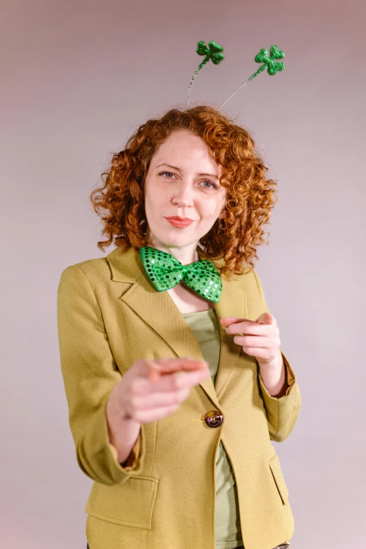 a woman with red hair and a green bow tie, trending on pexels, happening, wearing green suit, wikihow, pointing, curly haired