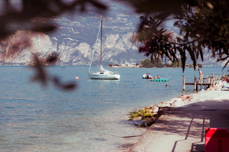 a couple of boats that are in the water, by Carlo Martini, pexels contest winner, lake background, soft shade, sail made of human skin, vhs colour photography
