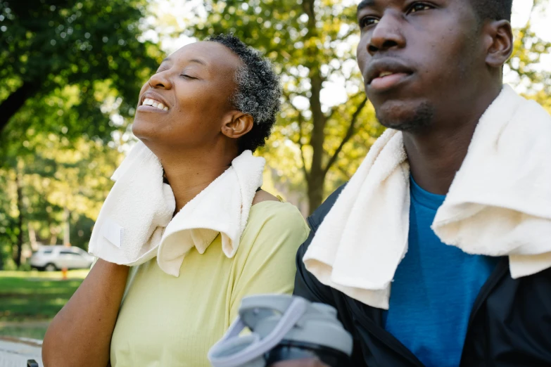 a man and a woman sitting on a park bench, wearing a towel, profile image, wearing fitness gear, dark-skinned