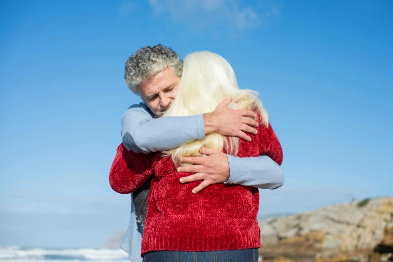 a man and woman hugging on the beach, supportive, marsden, older male, high quality product image”