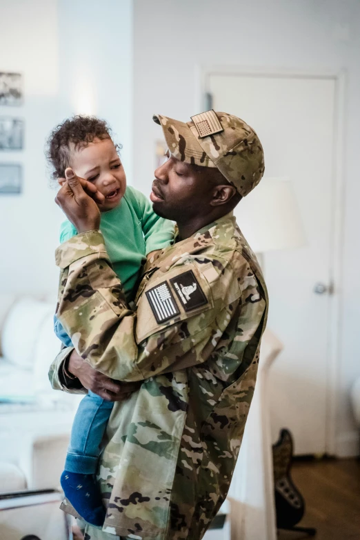 a soldier holding a child in his arms, pexels contest winner, hgtv, fatherly, square, african american