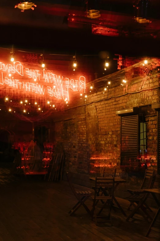 a red neon sign hanging from the side of a brick building, inspired by Bruce Munro, shady alleys, candlelit, rustic setting, neon ligh