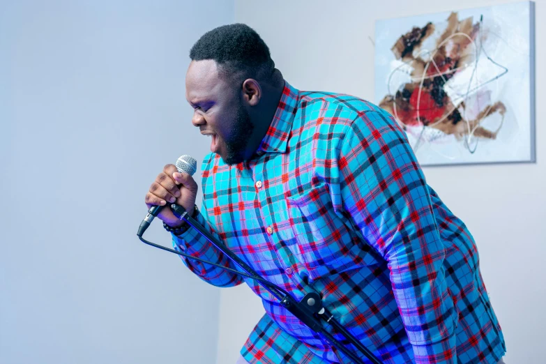 a man in a plaid shirt singing into a microphone, by Stokely Webster, pexels contest winner, visual art, godwin akpan, thicc, pastel', thumbnail