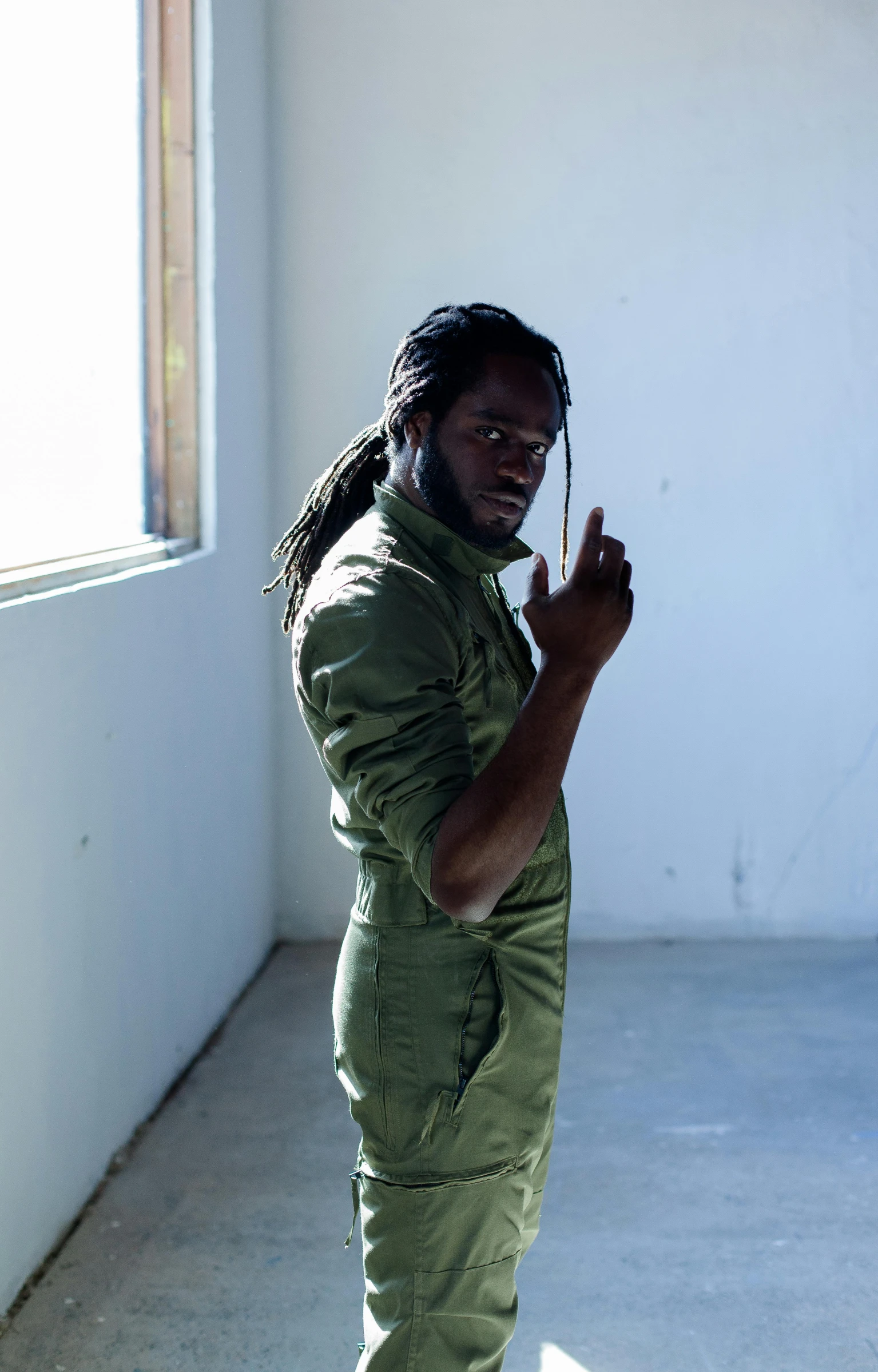 a man standing on a skateboard in a room, an album cover, unsplash, wearing military outfit, jamaican, thinker pose, ( ( dark skin ) )