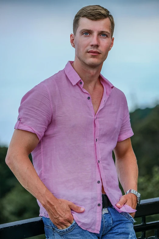 a man standing on a balcony with his hands in his pockets, a portrait, inspired by Julian Allen, trending on pexels, pink shirt, linen, mid-shot of a hunky, bali