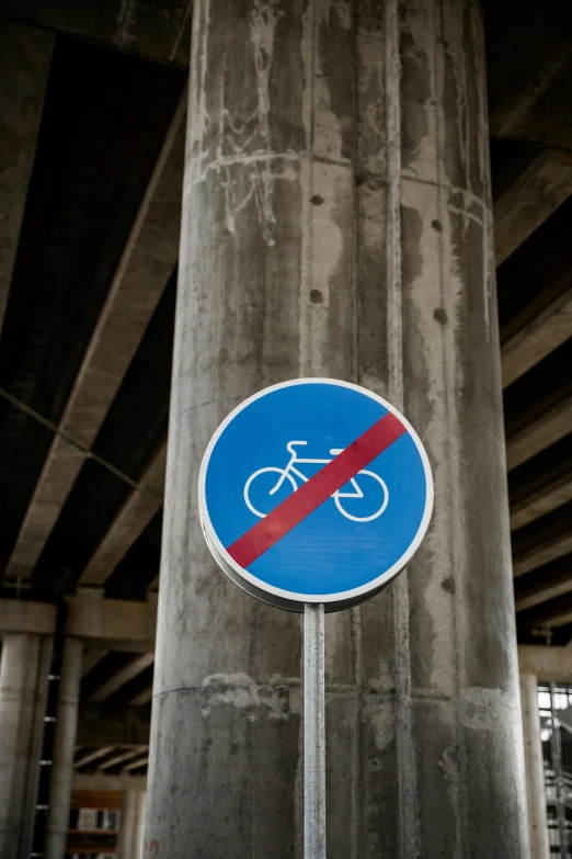 a close up of a street sign under a bridge, inspired by Jan Kupecký, unsplash, bicycles, no - text no - logo, 🚿🗝📝