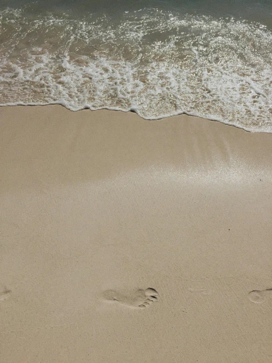 footprints in the sand of a beach next to the ocean, by Robbie Trevino, profile image, multiple stories, light tan, splash image