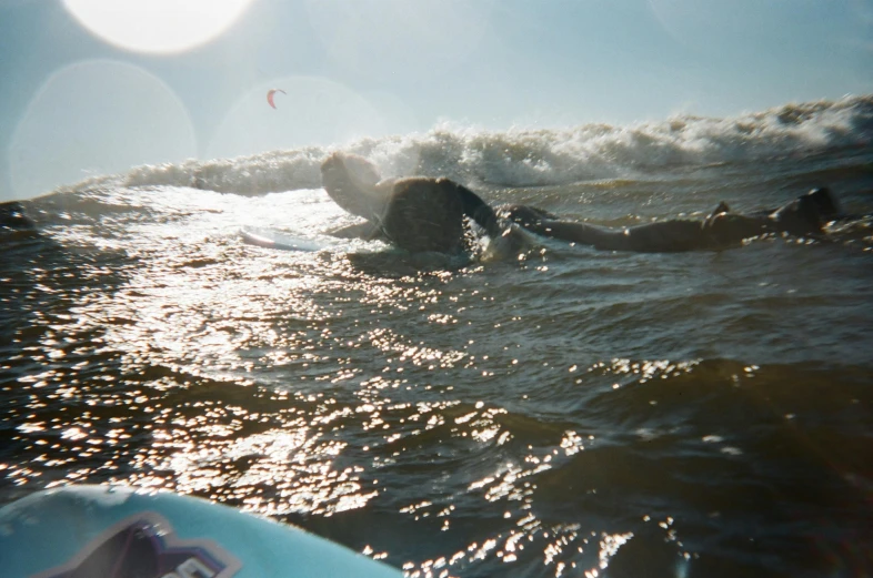 a man riding a wave on top of a surfboard, by Pamela Ascherson, unsplash, happening, taken with a disposable camera, blinding sun, people swimming, low quality footage