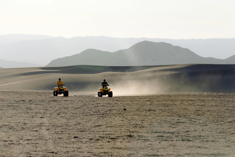 two people riding four wheelers in the desert, flickr, square, black sand, background image, craters