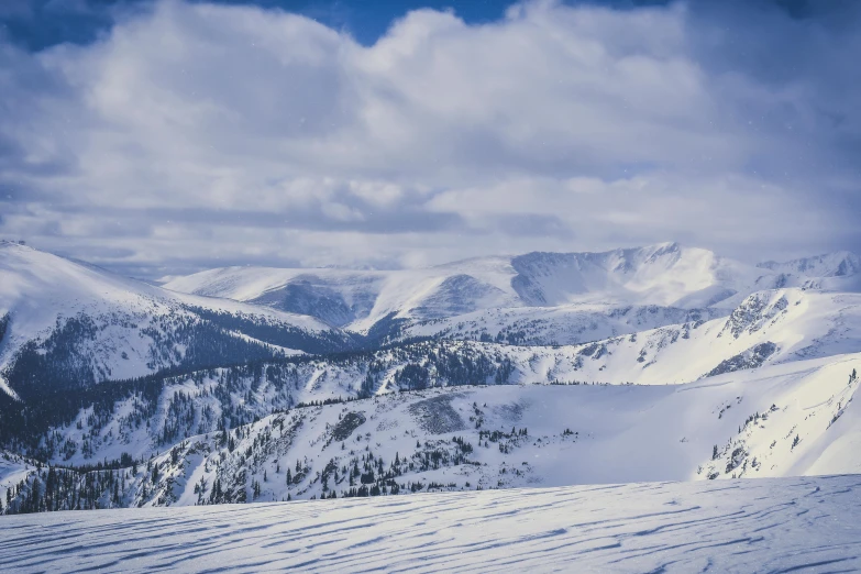 a man riding skis down a snow covered slope, pexels contest winner, vast mountain landscape, 90's photo, colorado mountains, a cozy