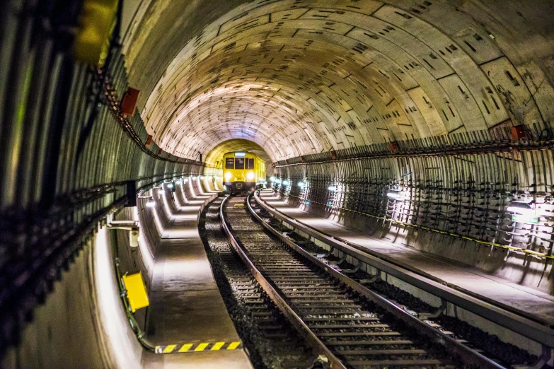 a train traveling through a tunnel next to a train track, underground lab, instagram post, metal towers and sewers, getty images