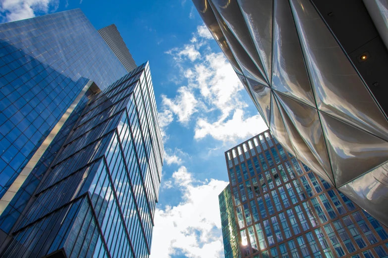 a couple of tall buildings sitting next to each other, inspired by Richard Wilson, unsplash, modernism, canopies, blue sky above, with shiny glass buildings, three views