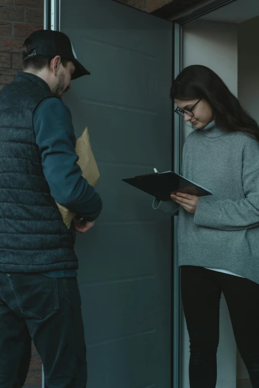 a man and a woman standing in front of a door, delivering mail, reddit post, holding a clipboard, alessio albi