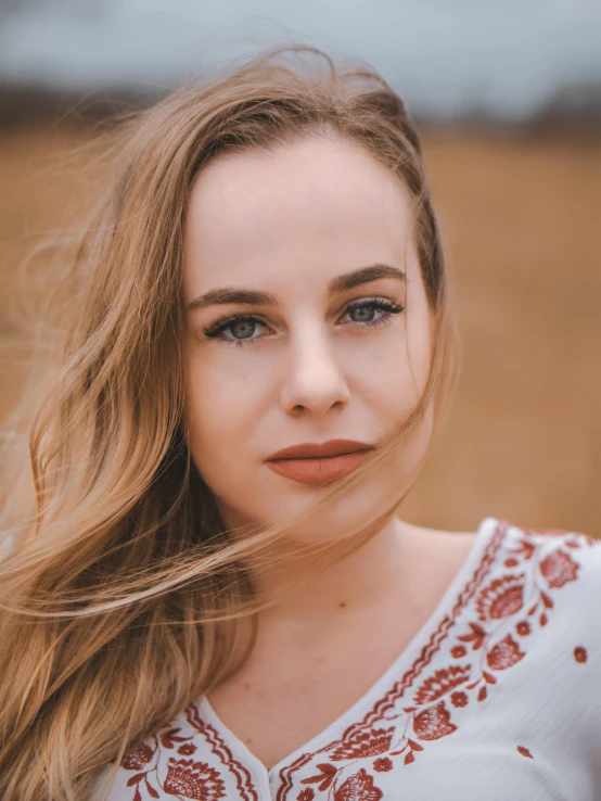 a woman with long hair standing in a field, trending on pexels, blue eyes and a wide face, 🤤 girl portrait, headshot profile picture, large eyebrows