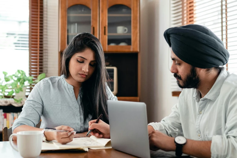 a man and a woman sitting at a table with a laptop, a screenshot, pexels contest winner, indian, writing on a clipboard, college, teaching