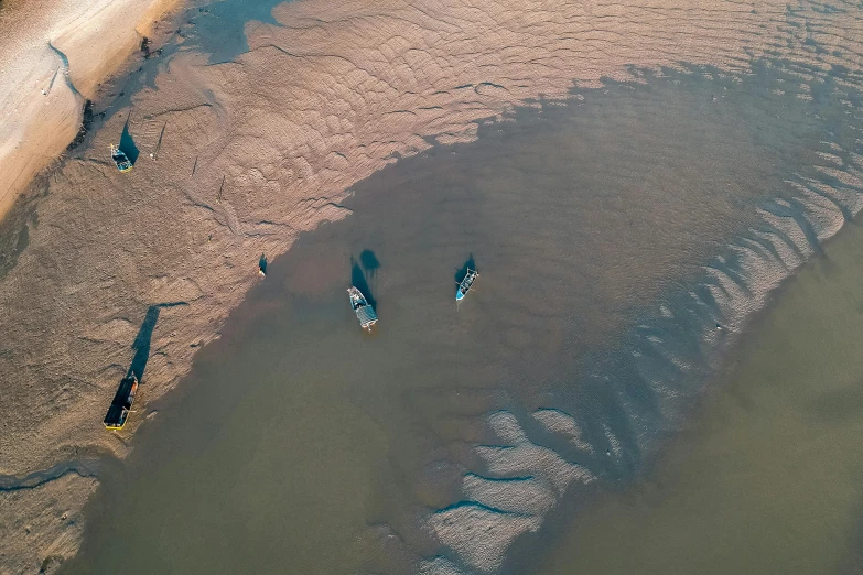 a group of people riding surfboards on top of a sandy beach, by Adam Marczyński, pexels contest winner, land art, 3 boat in river, thumbnail, subtle detailing, ships