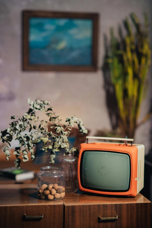 a small television sitting on top of a wooden table, inspired by Elsa Bleda, unsplash, modernism, teal and orange colors, antiques, 1970s photo, delightful surroundings