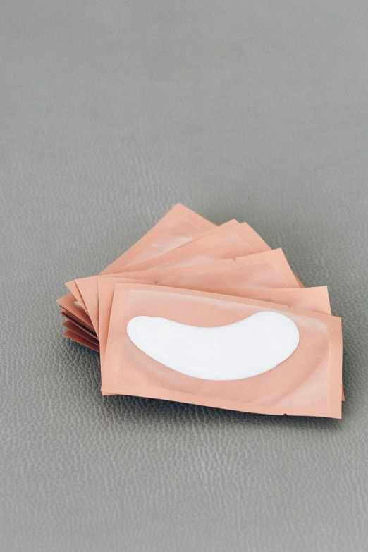 a pair of eye patches sitting on top of each other, gum tissue, peach, many smooth curves, diecut