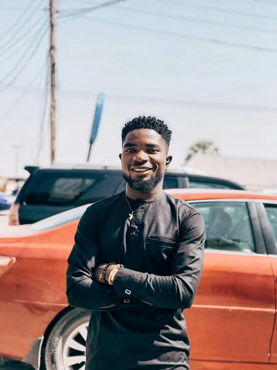 a man standing in front of a red car, jaylen brown, profile image, while smiling for a photograph, adebanji alade