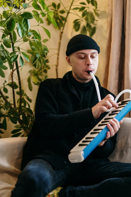 a man sitting on a couch holding a remote control, an album cover, reddit, antipodeans, pipes, andrea savchenko, musical keyboard, inflatable