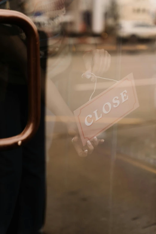 a close up of a window with a sign on it, by Jessie Algie, trending on unsplash, closed hands, shops, gloss, thumbnail