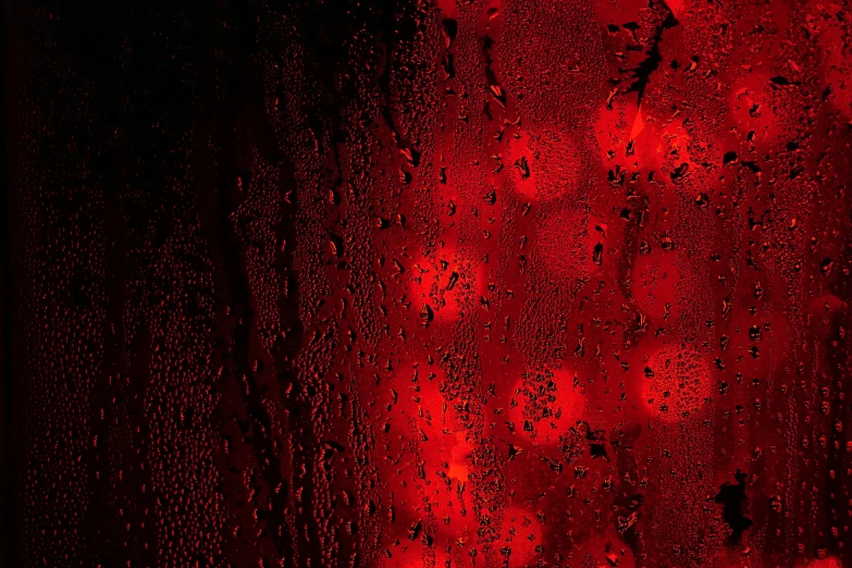 a red light shining through a rain covered window, inspired by Elsa Bleda, pexels, conceptual art, surface with beer-texture, red and obsidian neon, water bubbles, red - black