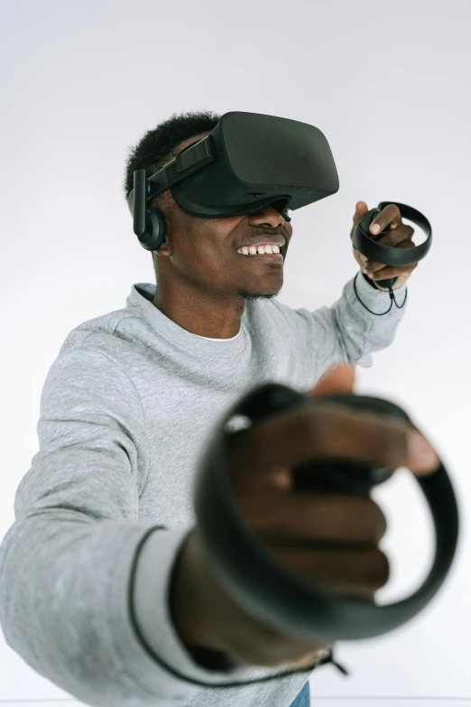 a man holding a video game controller in his hand, a digital rendering, trending on pexels, afrofuturism, floating vr headsets, wearing a headset, looking towards camera, oculus rift