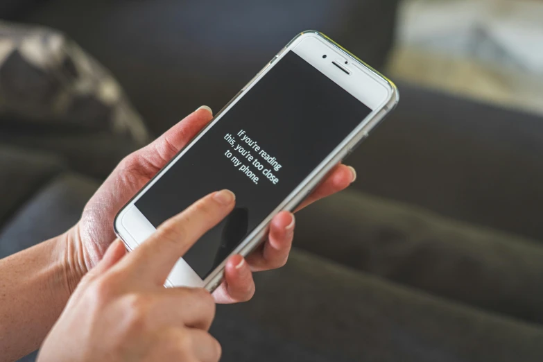 a close up of a person holding a cell phone, pexels, square, saying, readable, at home