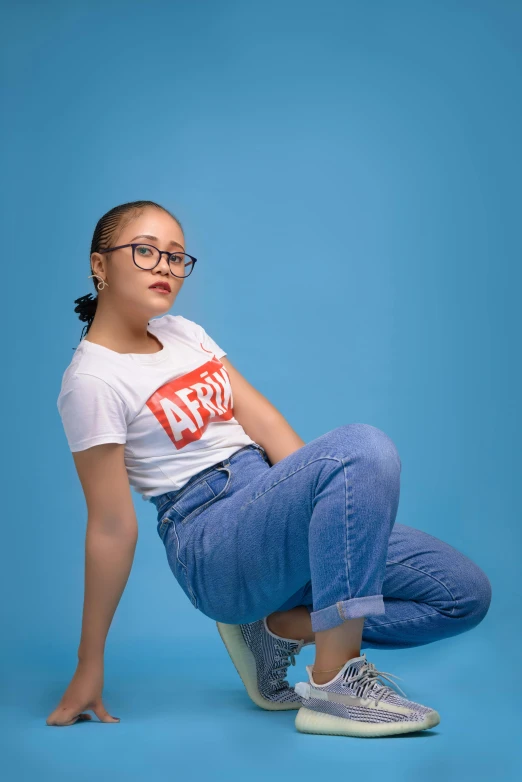 a woman in glasses sitting on a chair, an album cover, by Abidin Dino, trending on pexels, happening, jeans and t shirt, arms akimbo pose, uwu, pose 4 of 1 6