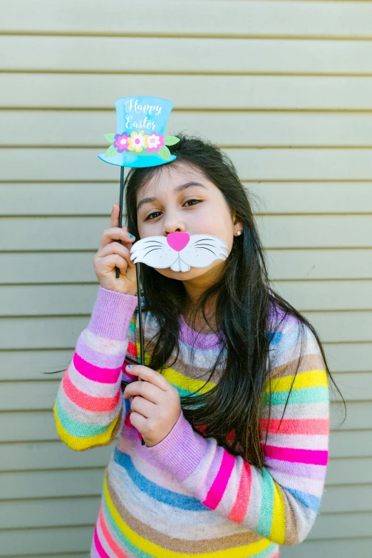 a young girl posing for a picture in front of a wall, easter, with mustache, cardboard cutout, promo image