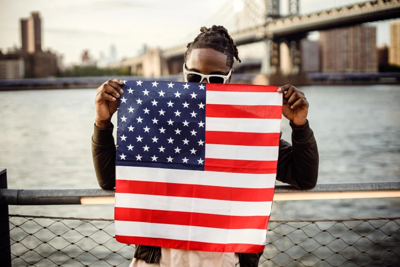 a woman holding an american flag in front of a bridge, an album cover, pexels contest winner, young thug, bandanas, handsome man, society 6