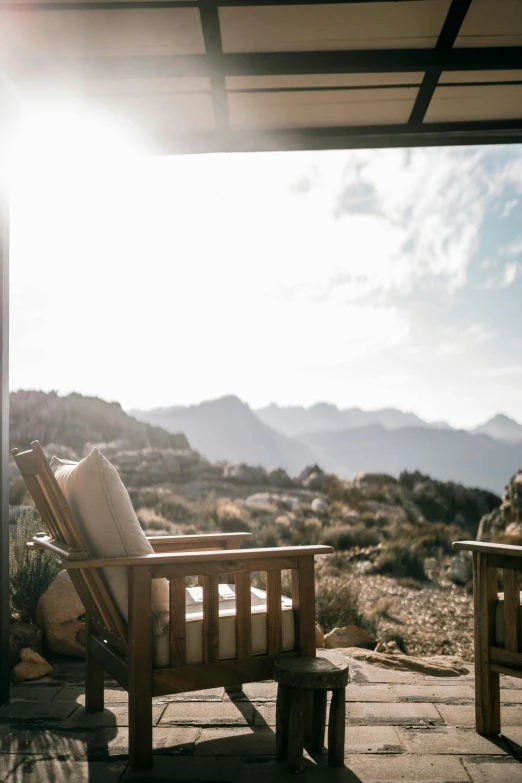 a couple of chairs sitting on top of a patio, by Johannes Voss, trending on unsplash, interior of a mountain hut, desert setting, full sun, balcony door