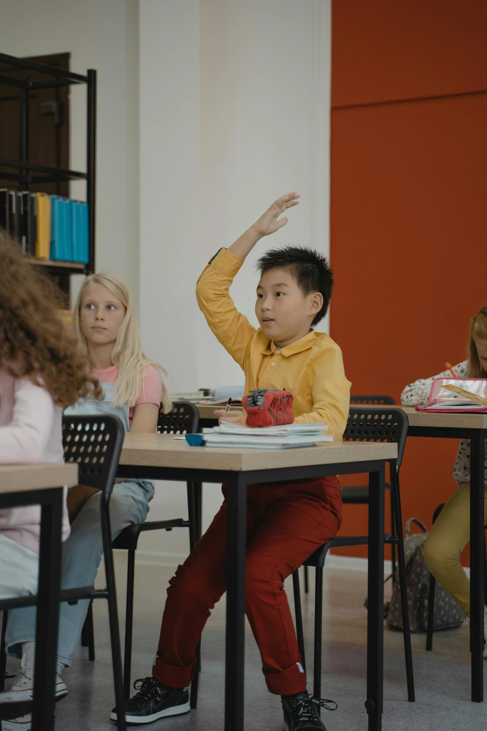 a group of children sitting at desks in a classroom, pexels contest winner, shrugging arms, vfx film, on his hind legs, ( ( theatrical ) )