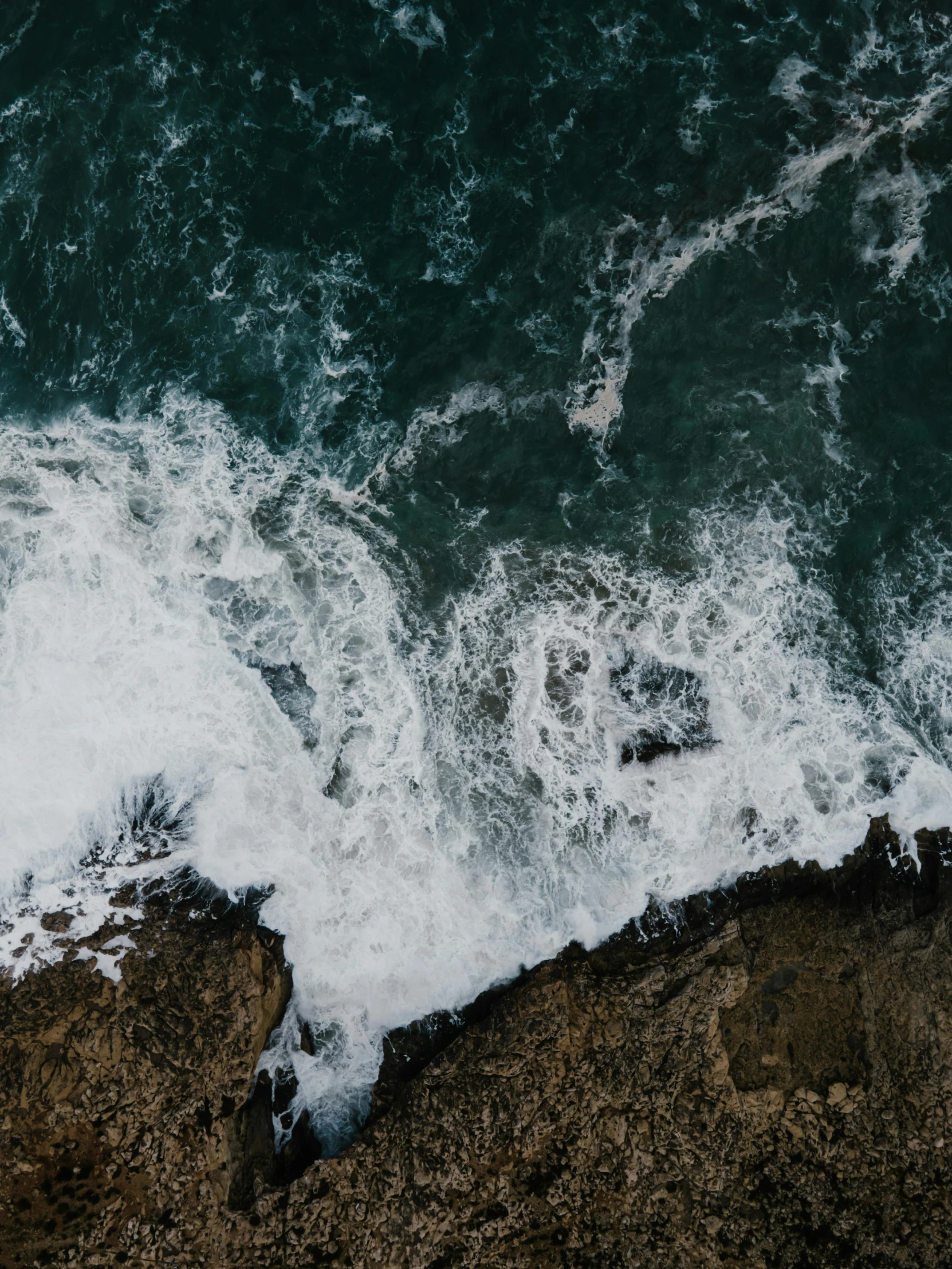 a bird's eye view of a body of water, pexels contest winner, waves crashing at rocks, looking threatening, slightly pixelated, trending on vsco