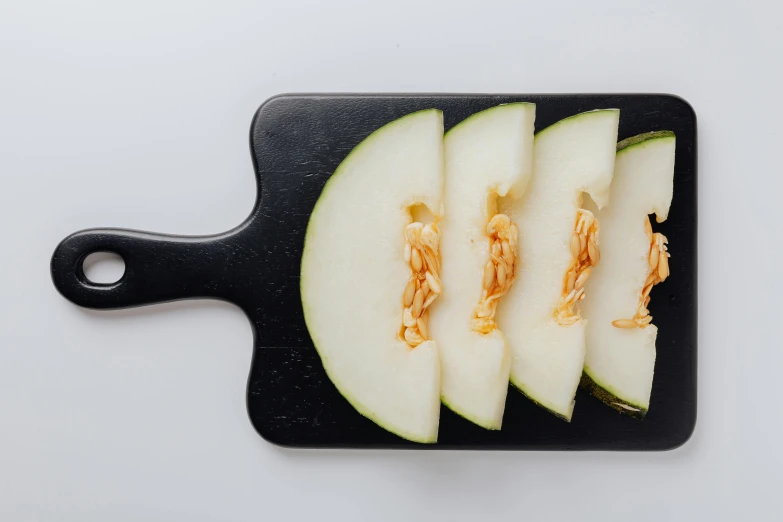 a cutting board with slices of melon on it, unsplash, pear, background image, gongbi, fan favorite