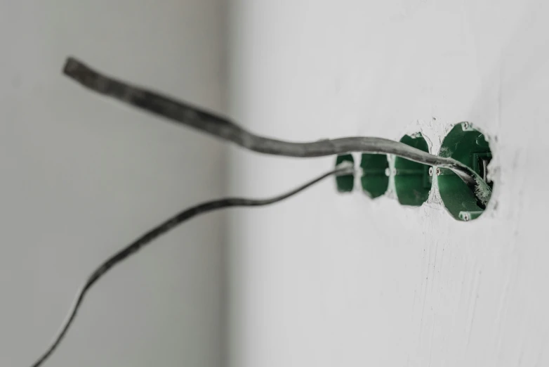a couple of wires that are connected to a wall, inspired by Lucio Fontana, unsplash, fluxus, green pupills, hyperrealism photo, made of glazed, gallery lighting