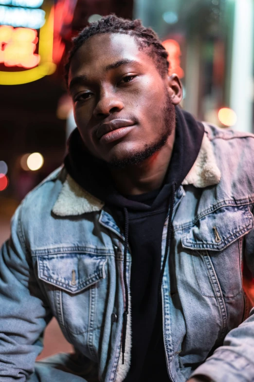 a man sitting on the curb of a city street, an album cover, trending on pexels, wearing a turtleneck and jacket, ( ( dark skin ) ), flashing lights, portrait of a rugged young man