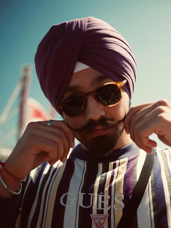 a man wearing a purple turban and sunglasses, inspired by Manjit Bawa, trending on pexels, teddy fresh, tiny thin mustache, roygbiv, **cinematic