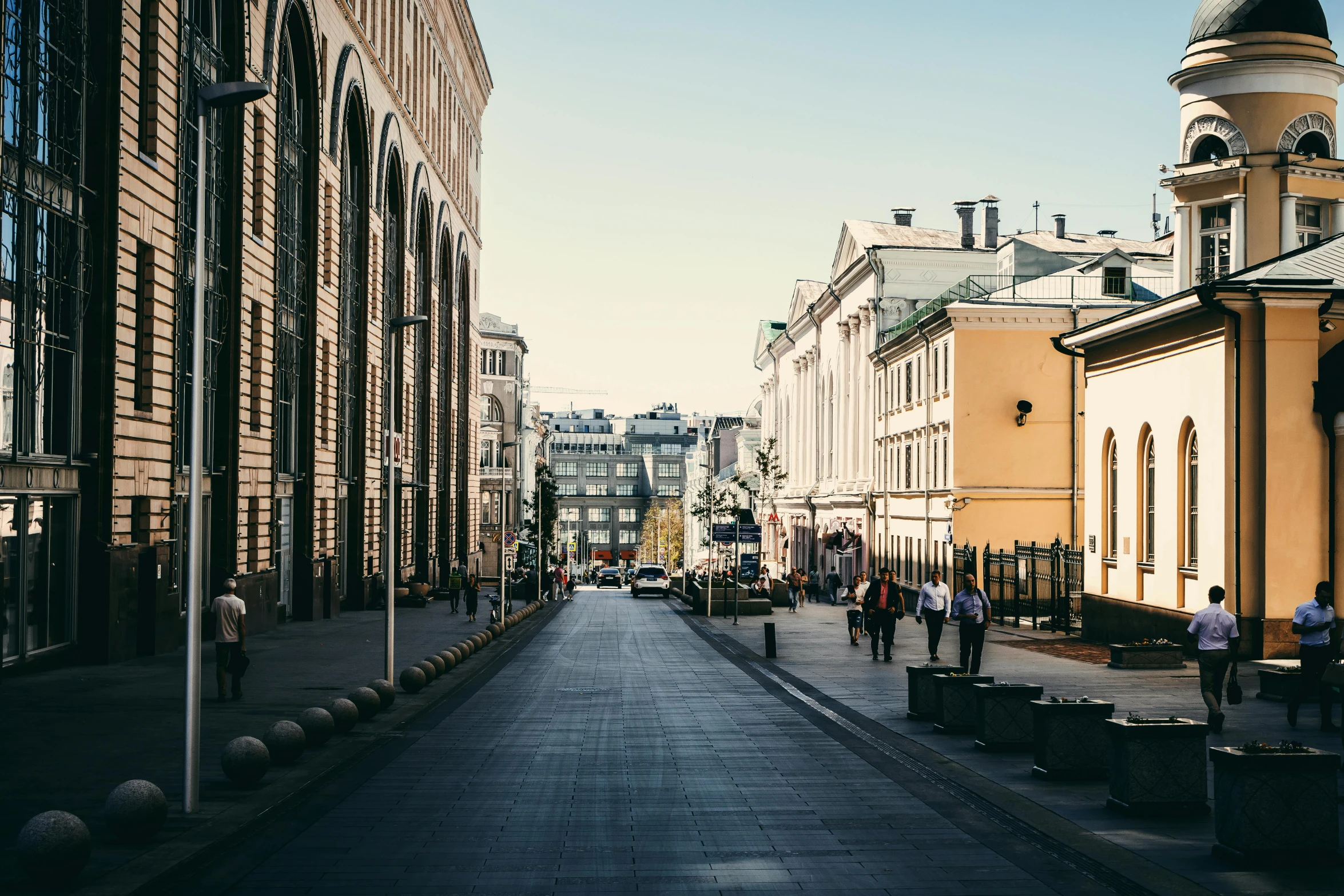 a group of people walking down a street next to tall buildings, pexels contest winner, neoclassicism, kremlin, afternoon light, square, julia hetta