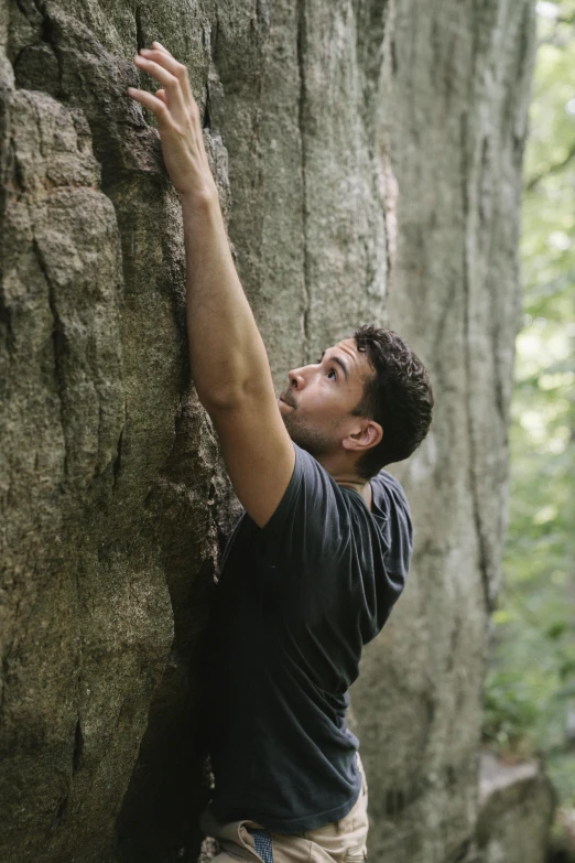 a man climbing up the side of a rock, ((trees)), oscar winning, sturdy body, jay bauman