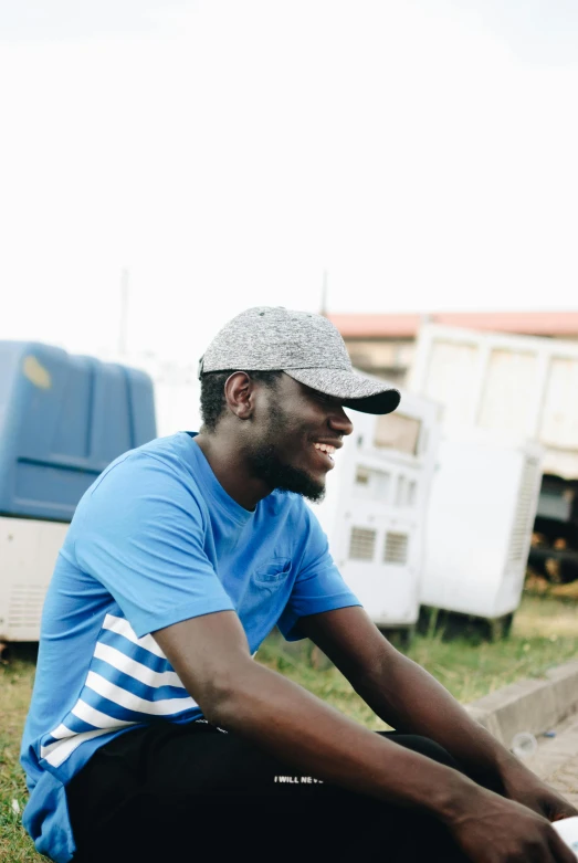 a man sitting on the ground with a skateboard, outside in a farm, adebanji alade, avatar for website, looking to the side